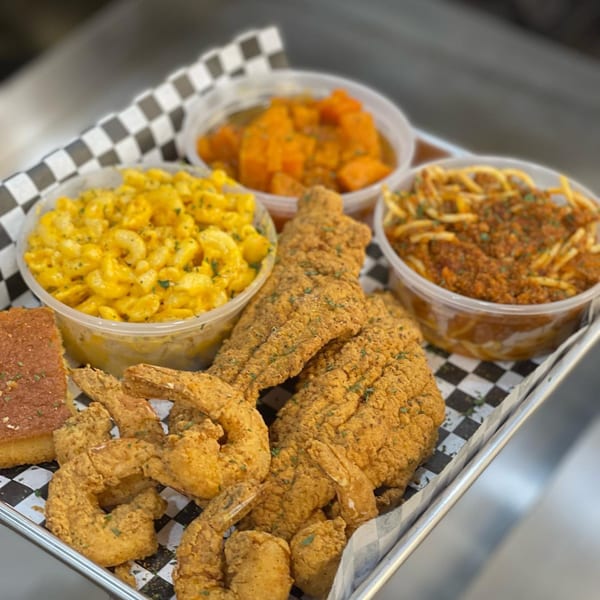 A Soul Goode meal with fried fish, shrimp, mac and cheese, spaghetti, candied yams, and cornbread.